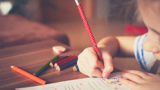 Child Sitting Filling In a Homeschooling Worksheet